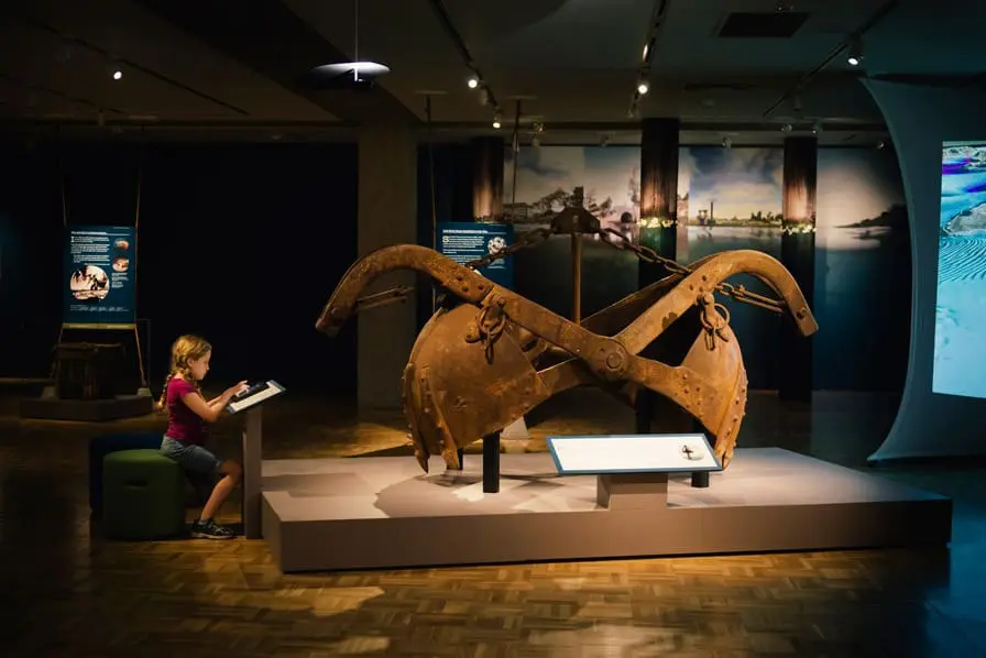 Clamshell dredges like this one scoop out material from the Bay's bottom. Much of that material is deposited on the floor of the Bay, depicted in a simulated flyover projected in the exhibition Above and Below: Stories From Our Changing Bay. Photo: Shaun Roberts. Courtesy of Oakland Museum of California.