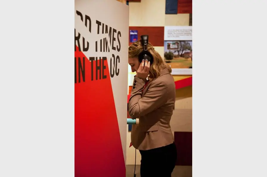 Oral histories of Fullerton residents play at listening stations throughout the interactive exhibit. Oakland Museum of California, 2013. Photo: Ryan LeBlanc.
