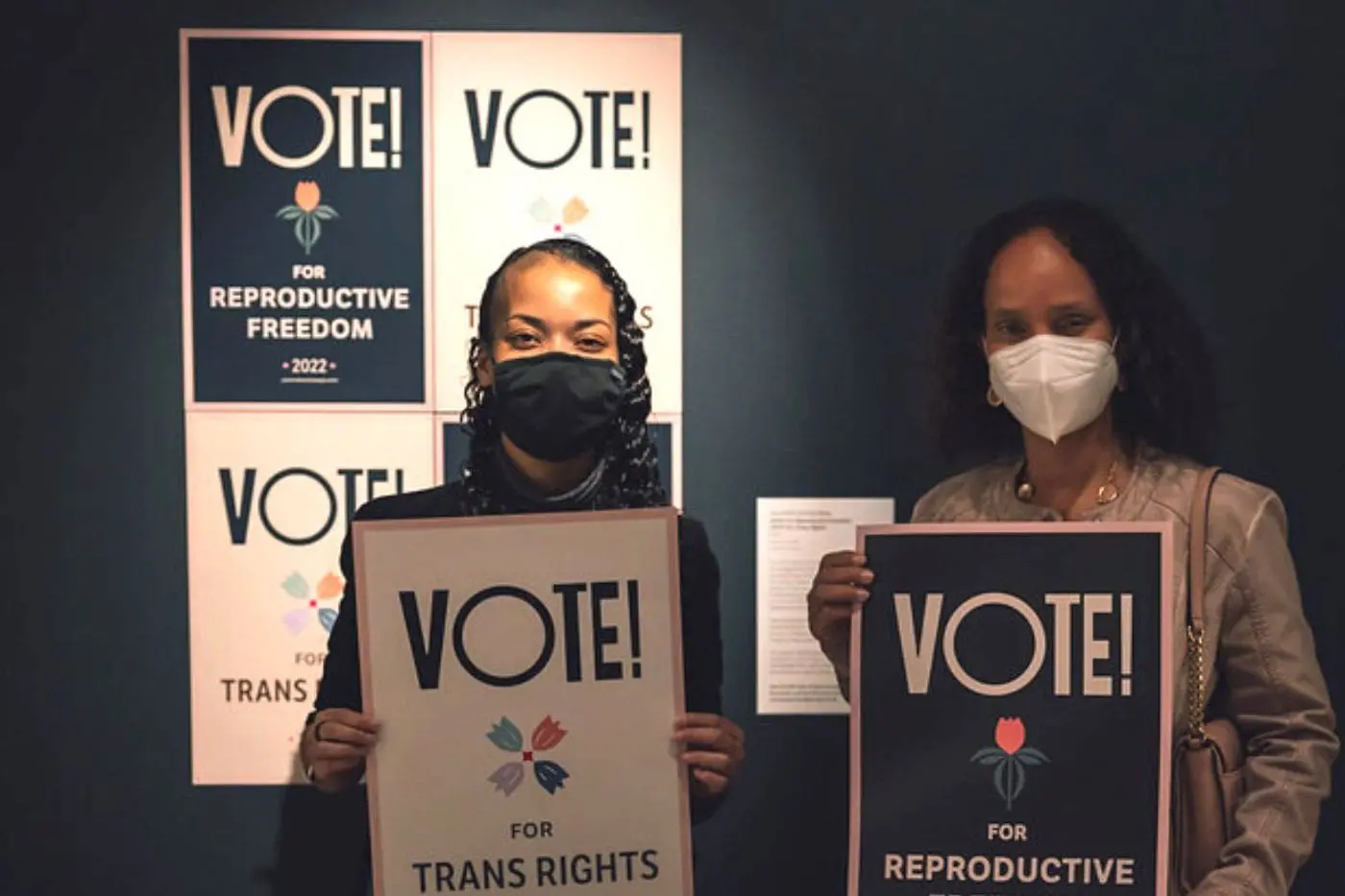 Dos mujeres que sostienen carteles de votación