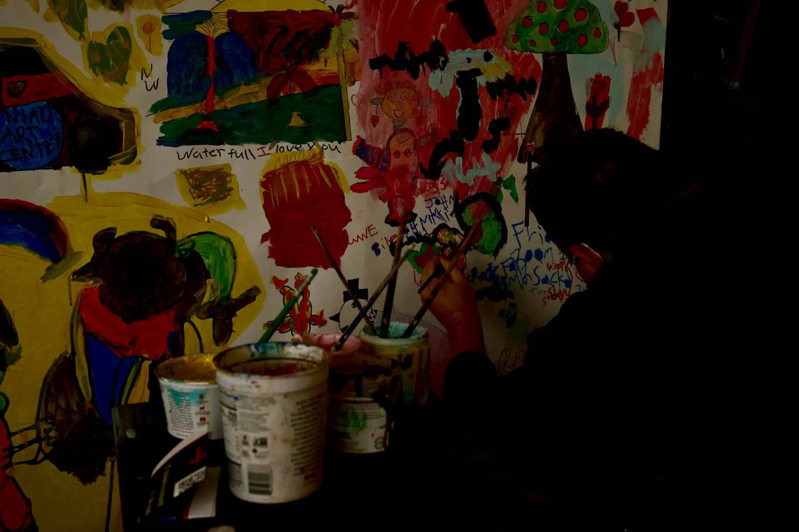 Back of artists head painting with left hand