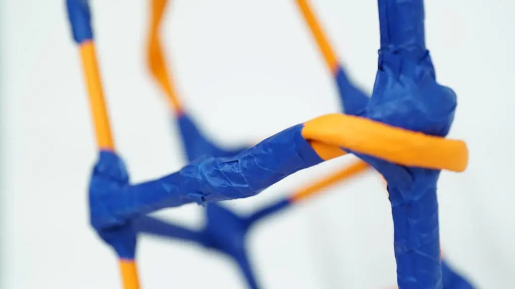 Sculpture made from orange piping and covered with blue tape