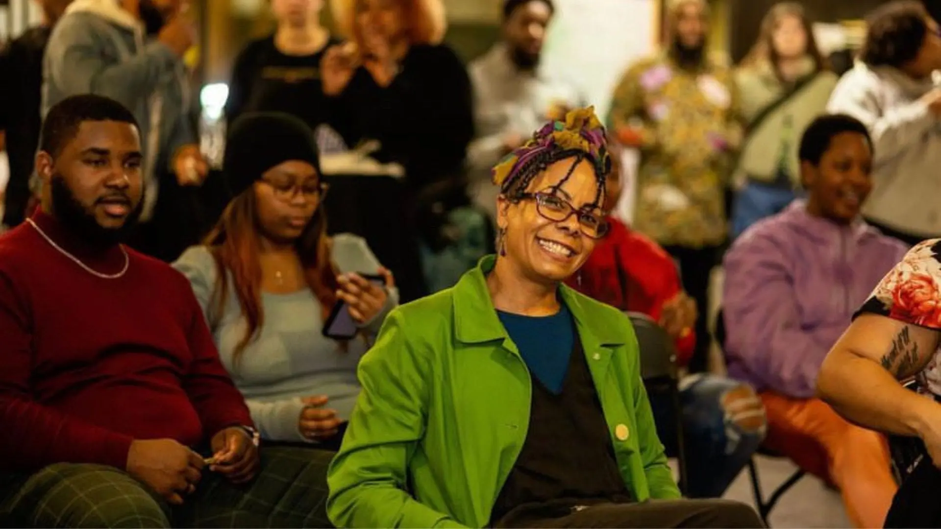 一个坐在人群中的女人对着镜头微笑