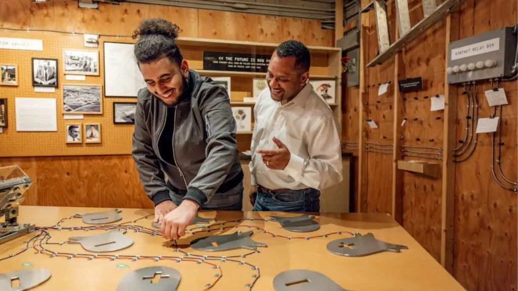 Two men looking at gears on a table at OMCA.