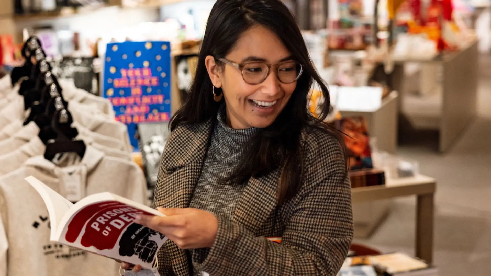 Mujer mirando un libro en la Tienda OMCA.