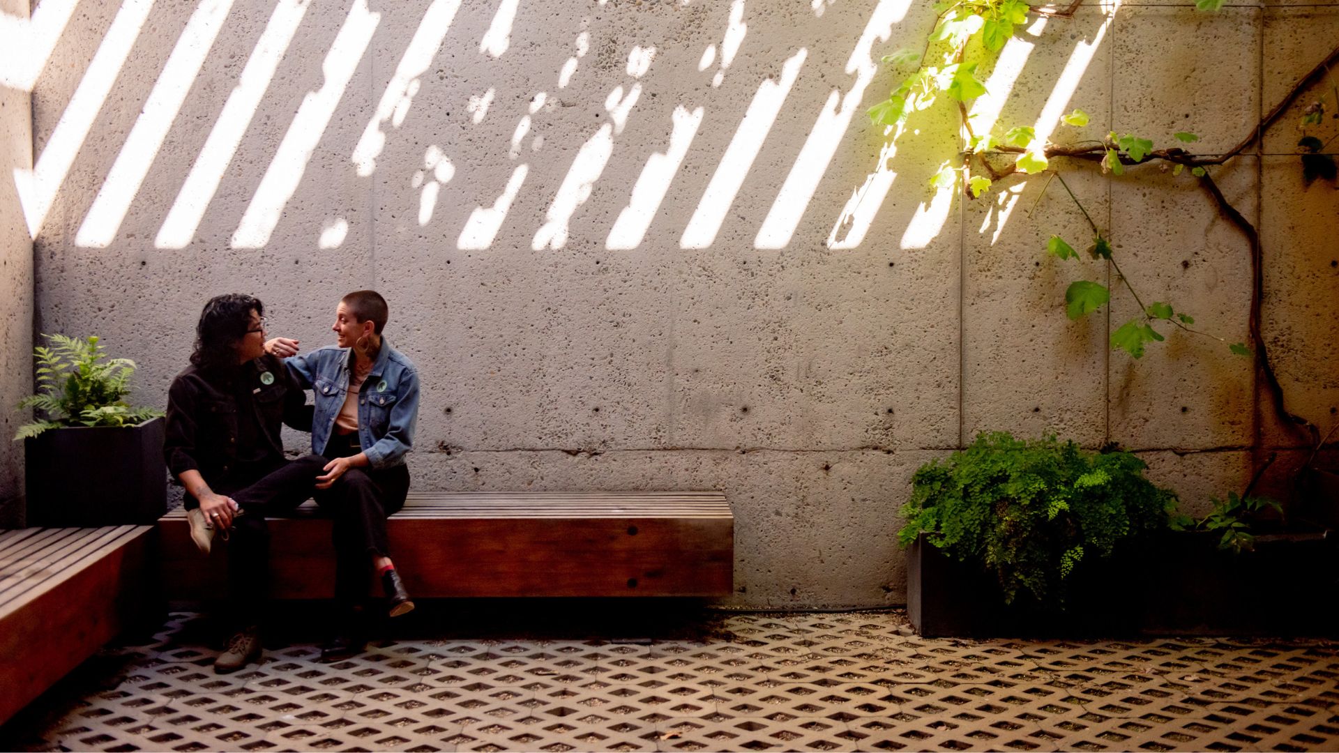 Two people sitting in a corner of OMCA's indoor garden