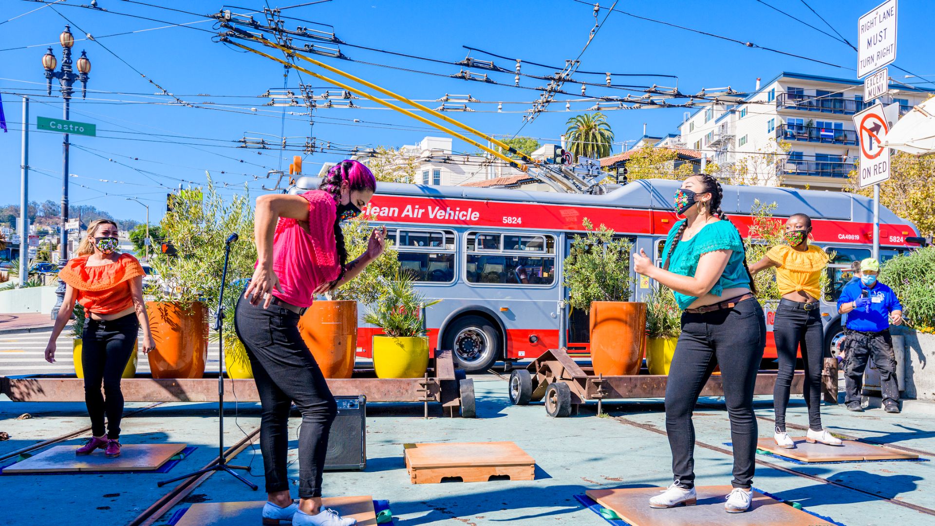 Women doing salsa near a bus stop