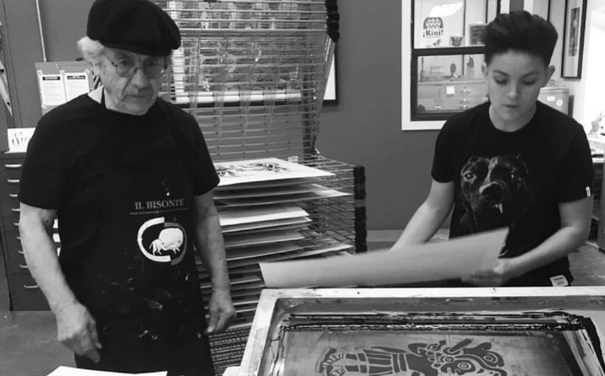 Malaquias Montoya helping a student with screenprinting in black and white